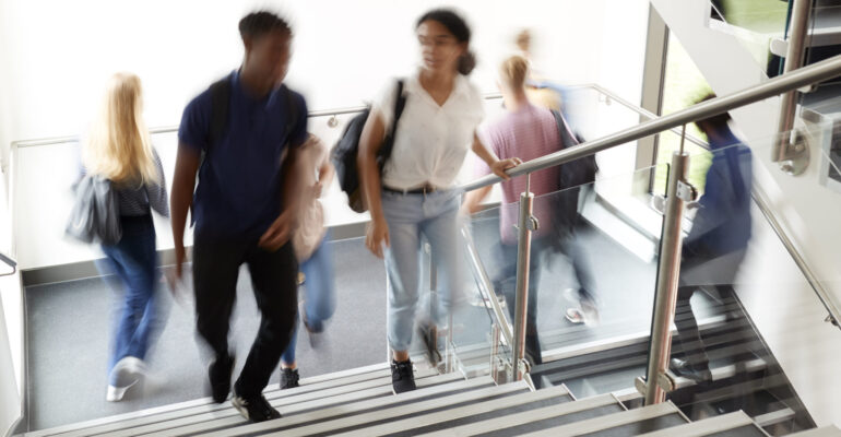 Motion Blur Shot Of High School Students Walking On Stairs Between Lessons In Busy College Building Motion Blur Shot Of High School Students Walking On Stairs Between Lessons In Busy College Building